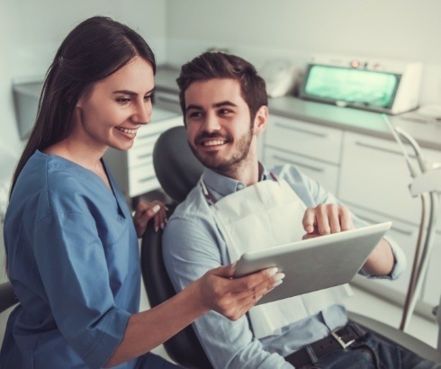 Dental team member showing tablet screen to a patient