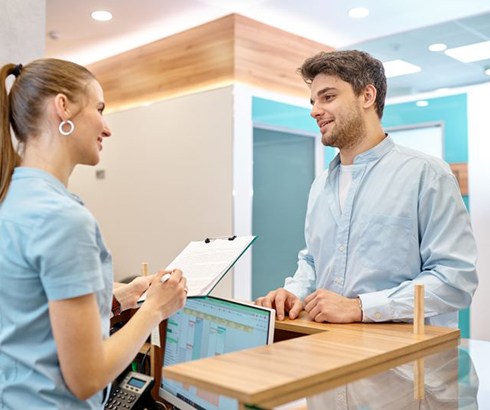 Patient standing at dental office front desk