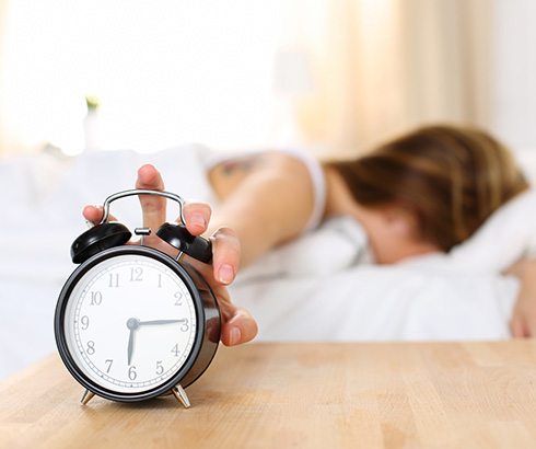 Woman in bed, struggling to wake up in morning