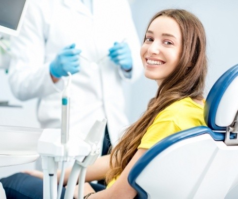 Woman in yellow blouse smiling during first visit to T M J dentist in Portland