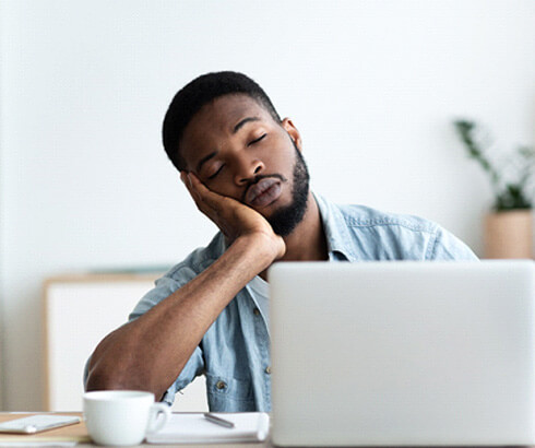 man tired at a desk