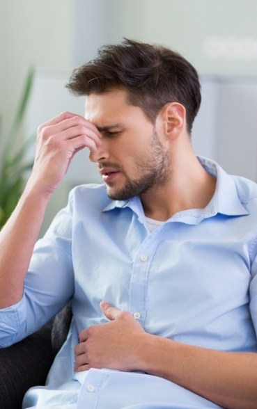 Man who needs T M J dental services in Portland pinching bridge of nose