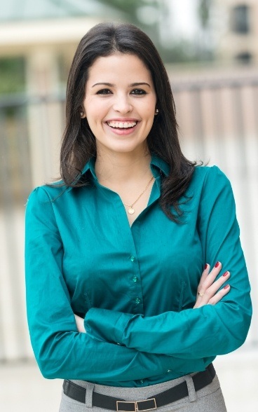 Smiling businesswoman standing with arms crossed outdoors