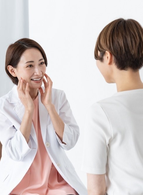 Dentist placing T M J sonogram on sides of a patient's head
