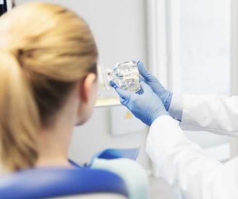 Dentist showing a patient a model of the jaws