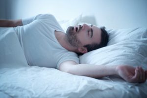 Snoring man in need of sleep apnea treatment 