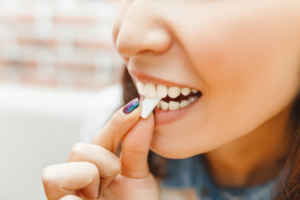 Woman biting into a tablet of chewing gum
