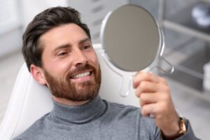 Man smiling after his Invisalign attachments were removed